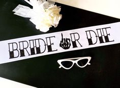 the bride and groom sash is next to sunglasses