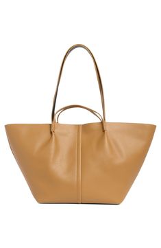 Made of smooth durable leather, this large tote bag features handle straps and shoulder straps for versatility of wear with a soft cotton lining and zip pouch. 23.5"W x 11.5"H x 6.75"D; 3" handle drop; 12" shoulder strap drop Cotton lining Leather Imported On-the-go Bucket Bag With Leather Handles, On-the-go Tote Shoulder Bag With Top Carry Handle, Leather Bucket Bag For On-the-go Use In Fall, Leather Double Handle Shoulder Bag For Shopping, Modern Leather Shopping Bags, Versatile Double Handle Leather Bags, Leather Satchel With Handle Drop, Chic Leather Bucket Bag With Handle Drop, Leather Satchel With Handle Drop And Double Handle