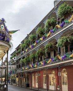 an old building with flowers on the balconies and hanging from it's sides