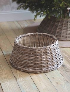 two wicker baskets sitting on top of a wooden floor next to a christmas tree