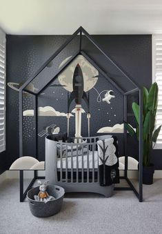 a baby's room decorated in black and white with a rocket ship painted on the wall