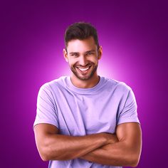 a man smiling with his arms crossed and looking at the camera while standing in front of a purple background