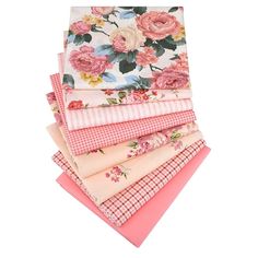 pink and white floral fabrics stacked on top of each other in different sizes, colors and patterns