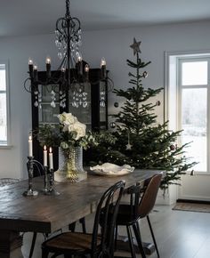 a dining room table with candles and christmas trees