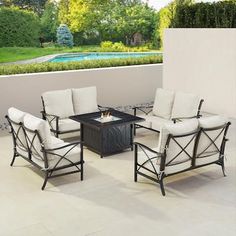 four chairs and a table on a patio with a pool in the backgroud