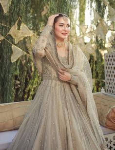 a woman in a wedding dress posing for the camera with her hand on her head