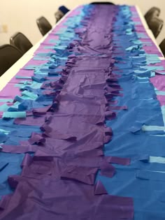a long table with purple and blue paper on it