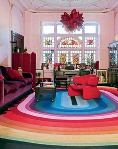 a living room filled with lots of furniture and colorful rugs on top of the floor