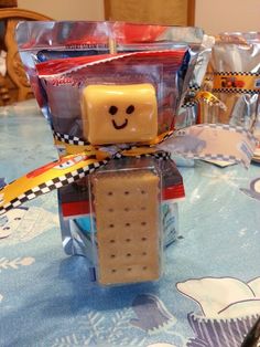 a lego figure is sitting on top of a table next to some candy and candies