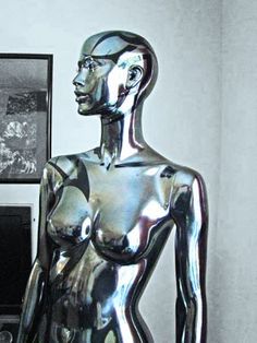 a black and white photo of a woman's body in shiny silver foil on display