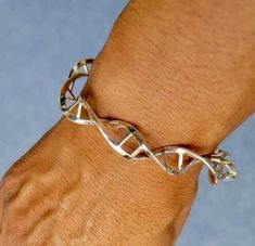 DNA...it's what's in you. Double Helix Sterling silver. This bracelet is part of a science themed series.  Arthur Ashe said,  1-Start where you are Starting where you are is the cell, the benezene ring, the DNA 2-Use what you have 3-Do what you can The DNA or double Helix in my art represents Home The metal art series is called Our Path is Different, Our Struggle is the Same! Dna Bracelet, Dj Gifts, Arthur Ashe, Double Helix, Our Path, Science Themes, Music Jewelry, Moonstone Bracelet, Silver Prices