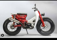 a red and white motorcycle parked on top of a gray floor