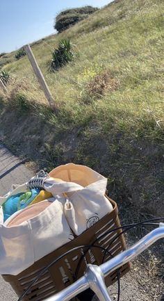 a bicycle is parked on the side of the road with a basket full of items