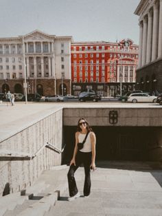 a woman standing on steps in front of some buildings