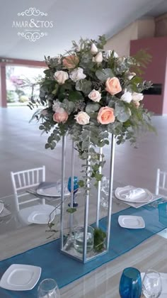 a vase with flowers on top of a table set for a formal dinner or party