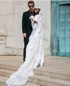 a bride and groom standing on some steps