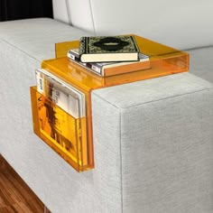 a couch with two books on it and a magazine rack attached to the back end