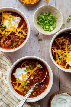 three bowls of chili with cheese and sour cream