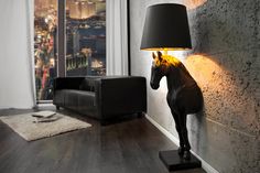 a horse lamp is on the floor in front of a wall with a cityscape behind it