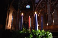 three candles are lit in front of the alter