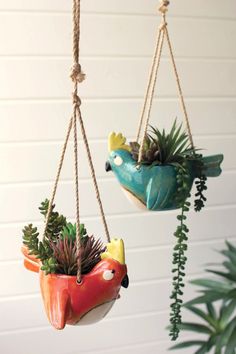 two hanging planters with plants in them and one has a bird shaped potted plant