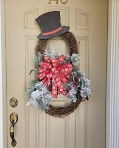 a wreath on the front door with a top hat