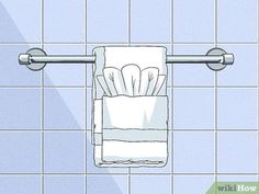 a white towel hanging on the wall above a toilet paper dispenser in a blue tiled bathroom