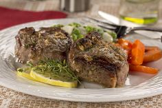 two pieces of steak and carrots on a plate