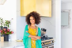 a woman standing in a kitchen with her arms crossed