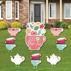 a lawn decoration with teapots and flowers in front of a house