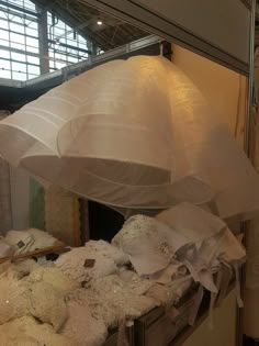 a large white umbrella sitting on top of a table next to other items in a room