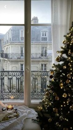 a christmas tree sitting in front of a window