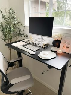 a desk with a computer, keyboard and mouse on it in front of a window