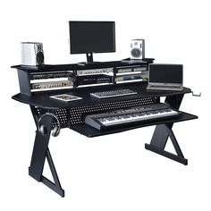 a computer desk with two monitors, keyboard and speakers on it's stand legs