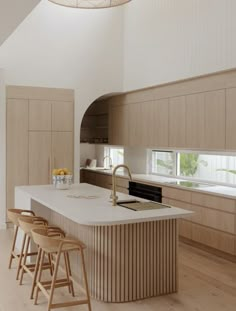 a large kitchen with an island and bar stools next to the counter top in front of it