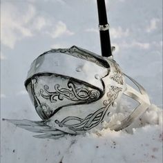 a snow covered ground with a metal object in it's center and a pen sticking out of the top