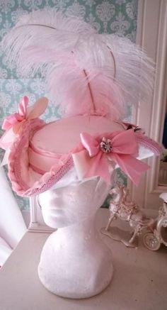 Marie Antoinette/ Rococo/Late Baroque Style Ladies Tricorn Hat (Feminine, Period Appropriate Size NOT a Mini) in heavy weight ivory satin. Both sides of the hat are decked with ivory grosgrain and pink satin ribbon rosettes centered by Silver Fleur de Lis charms. This piece measures 12 inches from end to end with an open back adorned with orange and peony flowers (artificial) popular at Versailles in this period of fashion. The posterior is lavish, with double-sided satin bows, topped with pink Tricorn Hat, Rococo Revival, Pink Hats, Rococo Fashion, Ribbon Rosettes, Peony Flowers, Womens Costumes, Fun Jewelry, Baroque Style