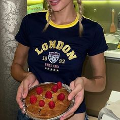 a woman holding a pie with raspberries on it