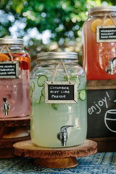 three mason jars filled with liquid sitting on top of a wooden stand next to each other