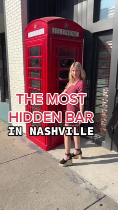 a woman standing in front of a red phone booth with the words, the most hidden bar in nashville