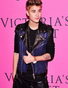 a young man in black leather pants and jacket at a victoria's secret event