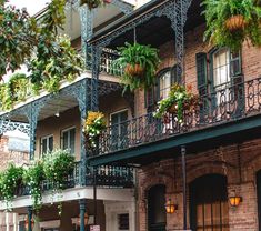 an old brick building with plants on the balconies