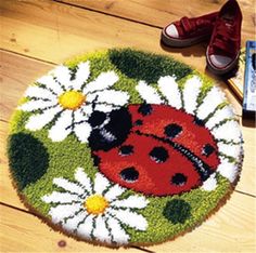 a ladybug and daisies door mat on the floor next to a pair of red shoes