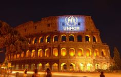 people are standing in front of an illuminated building