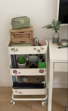 a white cart filled with lots of items on top of a wooden floor next to a desk