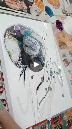 someone is drawing something on the paper with watercolors