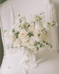 a bouquet of white flowers sitting on top of a chair