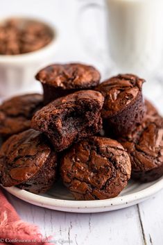 chocolate muffins on a plate with a glass of milk