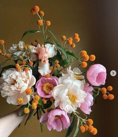 a person holding a bouquet of flowers in their hand