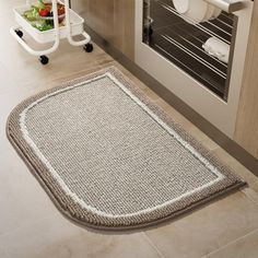 a kitchen area with an oven and rug on the floor